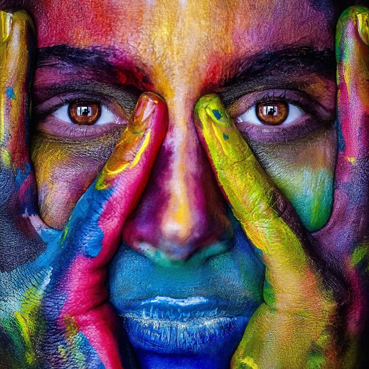 Photo d'une femme avec le visage peint de multiples couleurs